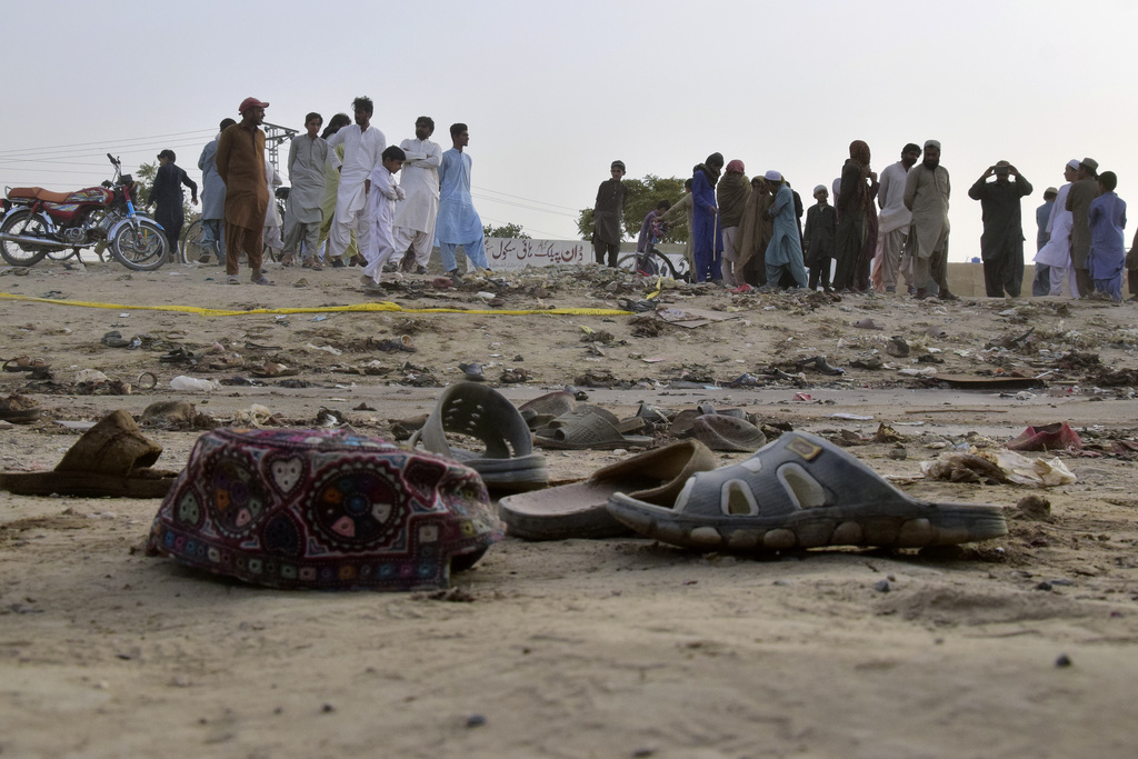 Local residents stand at the site of a suicide bombing in Mastung near Quetta, Pakistan, Friday, Sept. 29, 2023. Authorities in Pakistan say at least 52 people were killed and nearly 70 wounded after a suspected bomber blew himself up in a crowd of people celebrating the Prophet Muhammad’s birthday in the southwest of the country. (AP Photo/Arshad Butt)