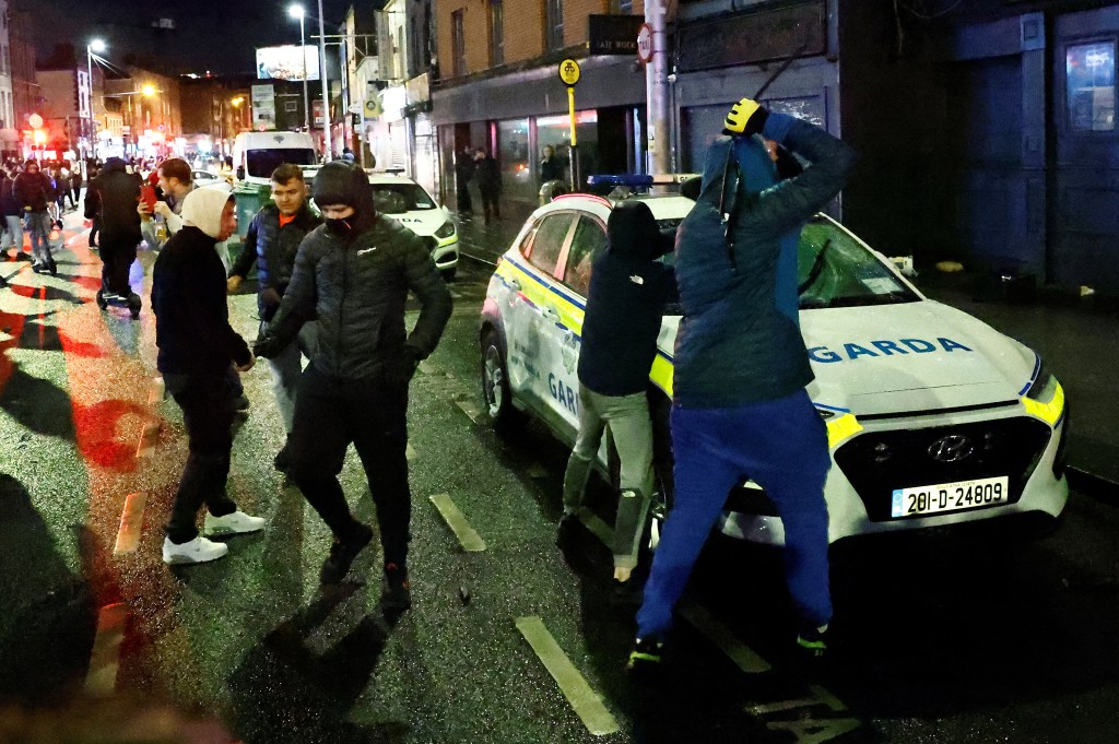 Protesters vandalise a police vehicle before setting it on fire during a riot following a school stabbing that left several children and adults, in Dublin, Ireland, November 23, 2023. REUTERS/Clodagh Kilcoyne