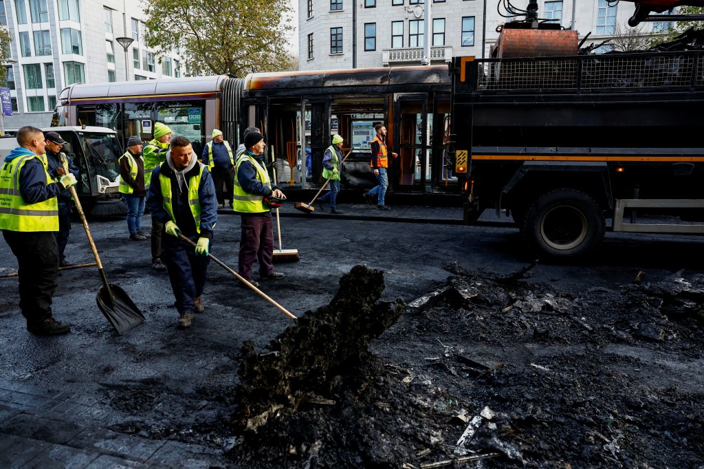 People remove remains of burned vehicles, following a riot in the aftermath of a school stabbing that left several children and adults injured, in Dublin, Ireland November 24, 2023. REUTERS/Clodagh Kilcoyne