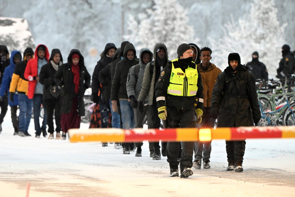 FILE PHOTO: Finnish Border Guards escort the migrants at the international border crossing at Salla, northern Finland, November 23, 2023.  Lehtikuva/Jussi Nukari via REUTERS