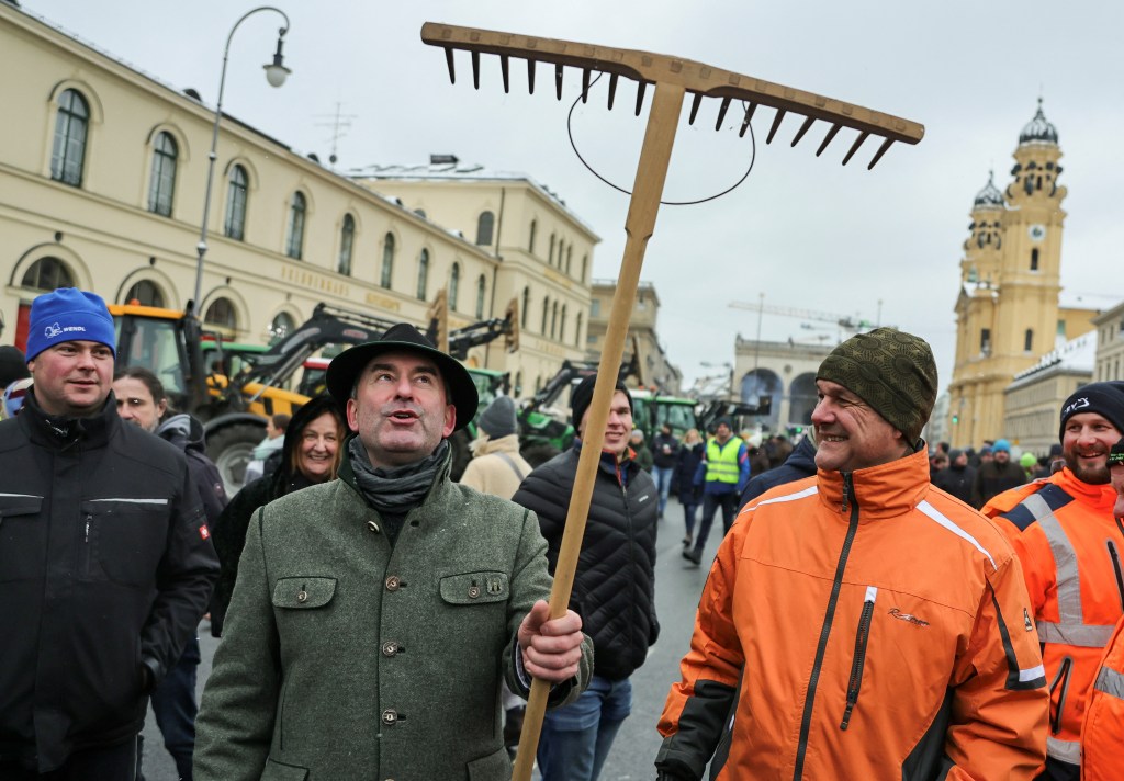 Bavarian Economic Minister Hubert Aiwanger holds a rake, as German farmers take part in a protest against the cut of vehicle tax subsidies of the so-called German Ampel coalition government, in Munich, Germany, January 8, 2024. REUTERS/Leo Simon