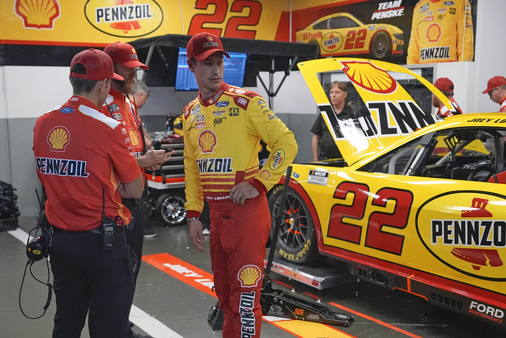 Joey Logano talks with team members in his garage after a practice session for the NASCAR Daytona 500 auto race at Daytona International Speedway, Friday, Feb. 16, 2024, in Daytona Beach, Fla. (AP Photo/John Raoux)