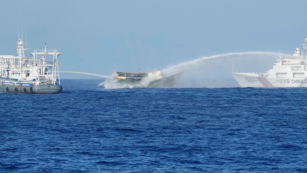 In the South China Sea, Chinese vessels surrounded a Philippine Coast Guard ship as journalists witness an aggressive confrontation.