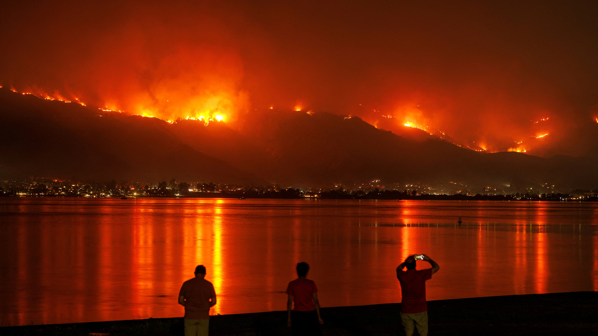 Western wildfires ravage U.S.; over 70 fires burn 6.9 million acres amid intense heat, with thousands evacuated.