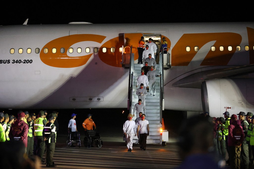 Venezuelan migrants deported from US Naval Station Guantanamo Bay walk down from the Venezuelan Conviasa Airlines plane as they arrive at Simon Bolivar International Airport in Maiquetia, Venezuela on February 20, 2025. The United States deported 177 migrants from its military base in Guantanamo, Cuba to their homeland in Venezuela Thursday, the latest sign of cooperation between the long-feuding governments. (Photo by Pedro MATTEY / AFP) (Photo by PEDRO MATTEY/AFP via Getty Images)